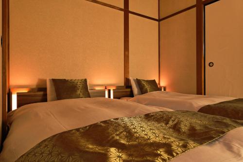 two beds in a room with lights on them at Ibaragi House in Kanazawa in Kanazawa