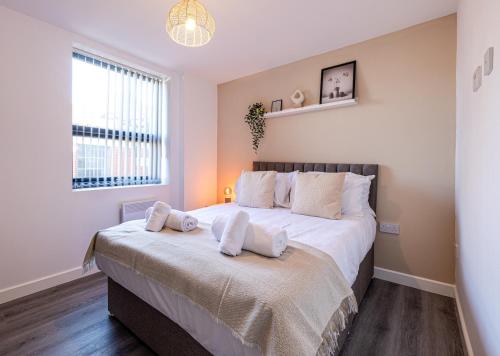 a bedroom with a large bed with two pillows on it at Stunning 1 bed apartment in the heart of Stockport in Stockport