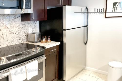 een keuken met een koelkast en een fornuis bij FREE PARKING Waikiki Luxury Ilikai Studio City View in Honolulu