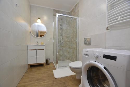 ein Badezimmer mit Waschmaschine und Toilette in der Unterkunft Apartament SZMARAGDOWY z garażem Centrum Gliwic-Klimatyzacja in Gliwice