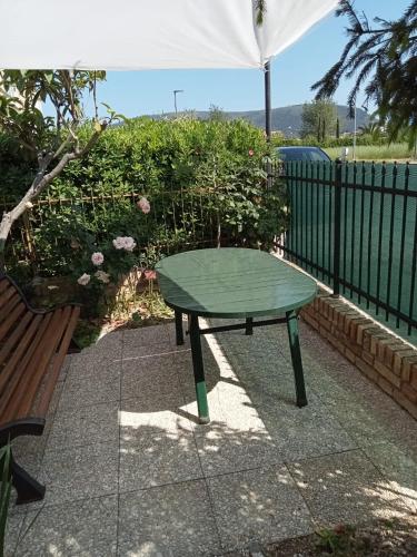 a green table sitting on a sidewalk next to a bench at N247 - Numana, meraviglioso quadrilocale in posizione strategica in Numana