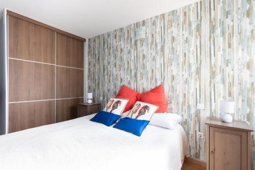 a bedroom with a bed with red and blue pillows at Home2Book Sea Views Caletillas in Candelaria