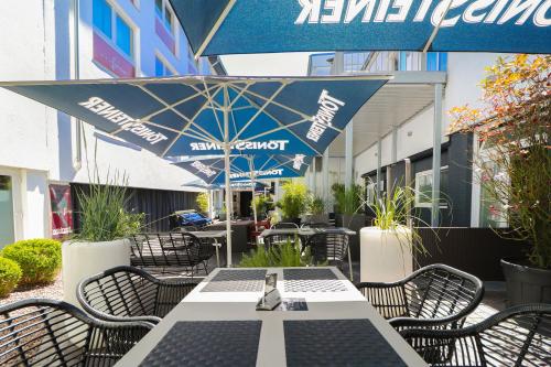 a table and chairs with an umbrella on a patio at Hotel Haverkamp in Bremerhaven