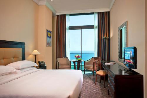 a hotel room with a bed and a television at Raouche Arjaan by Rotana in Beirut