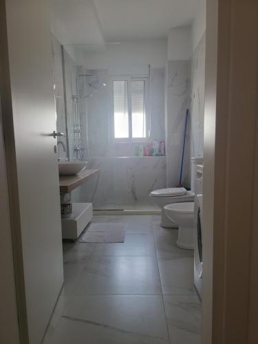 bagno bianco con lavandino e servizi igienici di SKY Apartment a Vlorë