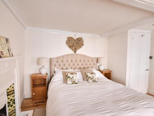a bedroom with a large white bed with two pillows at The Little Rose in Lyme Regis