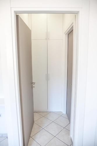 a closet with white cabinets and a tiled floor at Rimini Bay Suites&Residence in Rimini