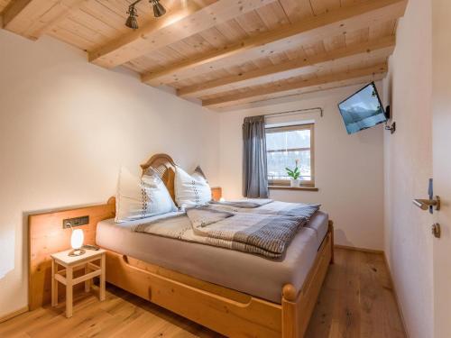 - une chambre avec un lit dans une pièce dotée d'une fenêtre dans l'établissement Trattenbachhof, à Scheffau am Wilden Kaiser