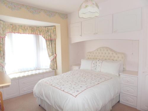 - une chambre avec un lit blanc et une fenêtre dans l'établissement Stay Llandudno, à Llandudno