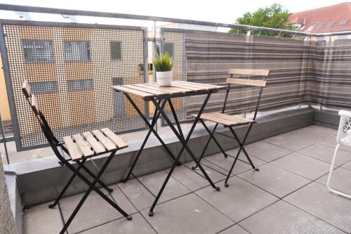 a table and two chairs on a balcony at FULL HOUSE Studios - KornhausPremium Apartment - Balkon, WiFi in Dessau