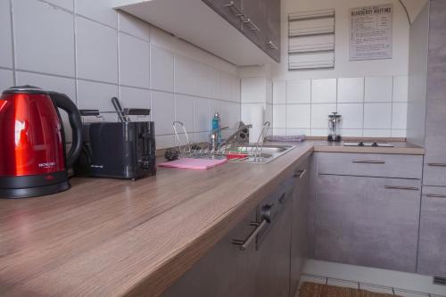 a kitchen with a red appliance on a wooden counter at FULL HOUSE Studios - KornhausPremium Apartment - Balkon, WiFi in Dessau