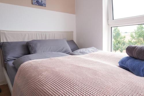 a bed sitting in a room with a window at FULL HOUSE Studios - KornhausPremium Apartment - Balkon, WiFi in Dessau