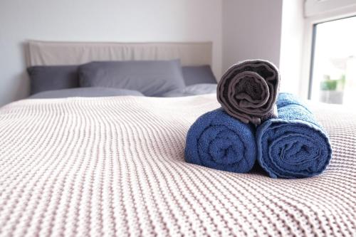 a pair of towels sitting on top of a bed at FULL HOUSE Studios - KornhausPremium Apartment - Balkon, WiFi in Dessau