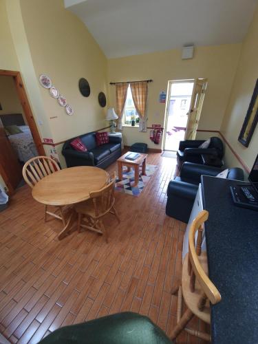 a living room filled with furniture and a tv at Slane Farm Hostel, Cottages and Camping in Slane