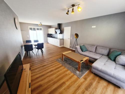 ein Wohnzimmer mit einem Sofa und einem Tisch in der Unterkunft DM Hotes & Apartments - Apartment Rasenweg in Dingelstädt
