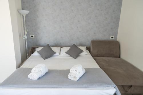 a bedroom with a bed with towels on it at Rimini Bay Suites&Residence in Rimini