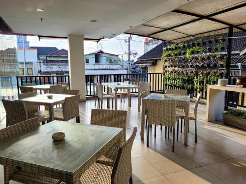 a restaurant with tables and chairs on a balcony at Cordela Kartika Dewi Yogyakarta in Yogyakarta