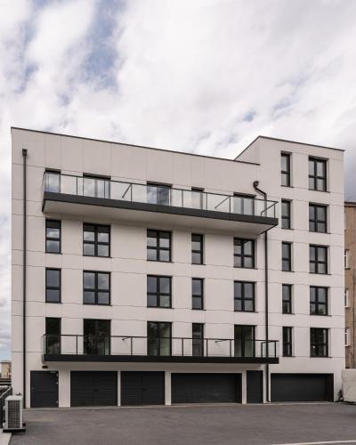 a white building with a balcony on top of it at Apartamenty Przystanek Morska in Gdynia