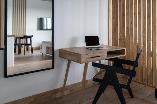 a wooden desk with a laptop on it next to a chair at Apartamenty Przystanek Morska in Gdynia