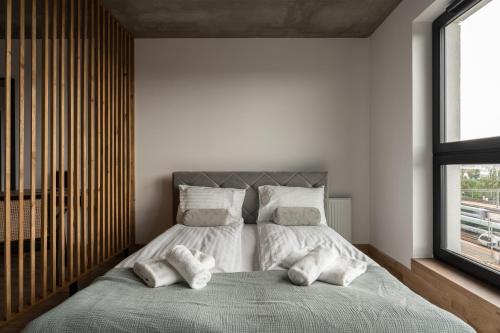 a bedroom with a bed with two pillows on it at Apartamenty Przystanek Morska in Gdynia