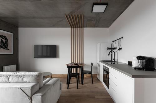 a kitchen and living room with a couch and a table at Apartamenty Przystanek Morska in Gdynia