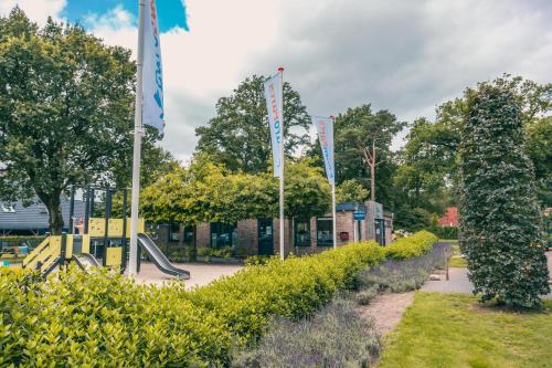 un parque infantil con banderas y un tobogán en EuroParcs Reestervallei, en IJhorst