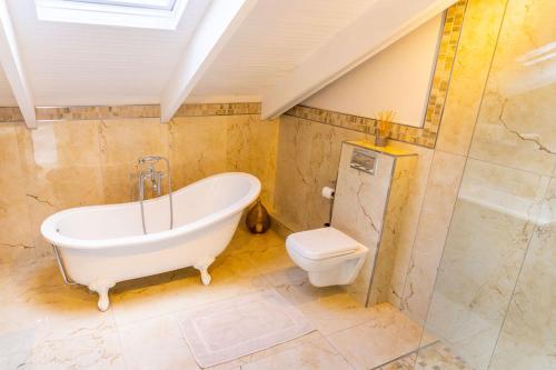 a bathroom with a bath tub and a toilet at TheLoft32 in Cape Town