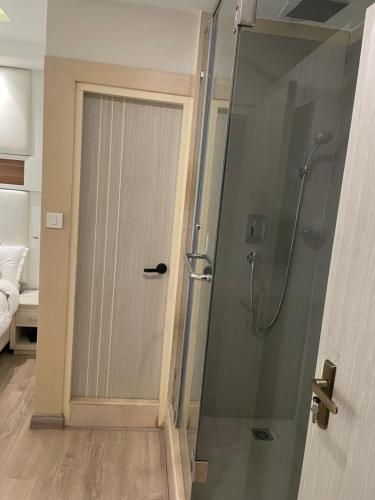 a shower with a glass door in a bathroom at Palmo Holiday Apartments in Kathmandu