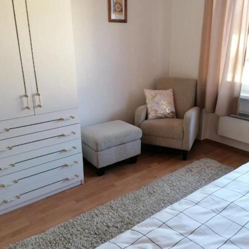 a living room with a chair and a dresser at Ubytovanie Sosna Muráň in Muráň