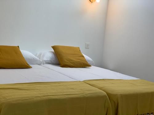 a bedroom with two beds with yellow pillows at Casita Mondoto, encanto en el Pirineo in Frajén