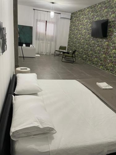 een kamer met 3 bedden en een flatscreen-tv bij Appartamento Calilla in Taranto