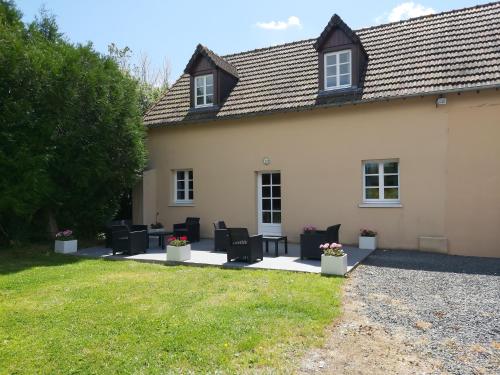 a house with chairs and tables in the yard at le bonheur des plumes in Montmartin-en-Graignes
