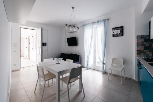 a kitchen and dining room with a white table and chairs at Le Isole di Anita in Lipari
