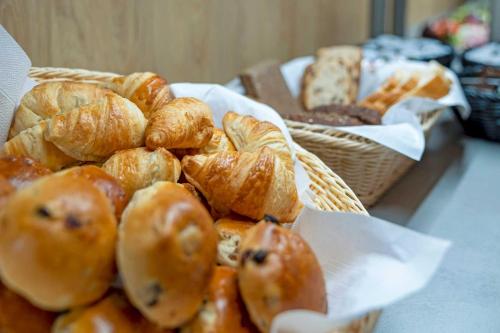 a pile of croissants and other pastries on a table at Hotel Landhaus Steinfeld in Greetsiel