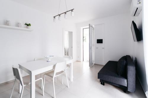 a white dining room with a white table and chairs at Le Isole di Anita in Lipari