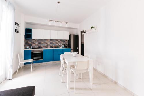 a kitchen with a white table and blue cabinets at Le Isole di Anita in Lipari