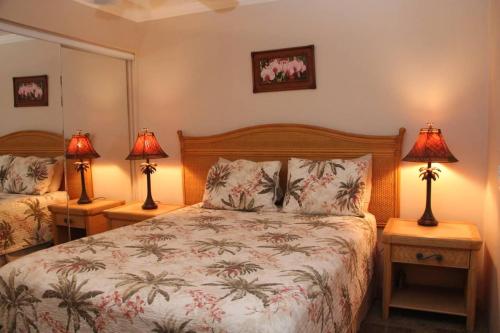 a bedroom with a bed with two lamps on two tables at Maalaea Kai Resort 213 in Wailuku