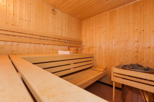 a sauna with wooden walls and a bench in it at Villa Puerto in Pobierowo