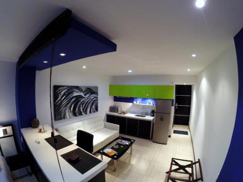 a living room with a couch and a kitchen at Aqua Granada Hotel in Cali