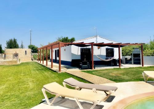 a patio with a hammock and a house at Casa Maria in Moncarapacho