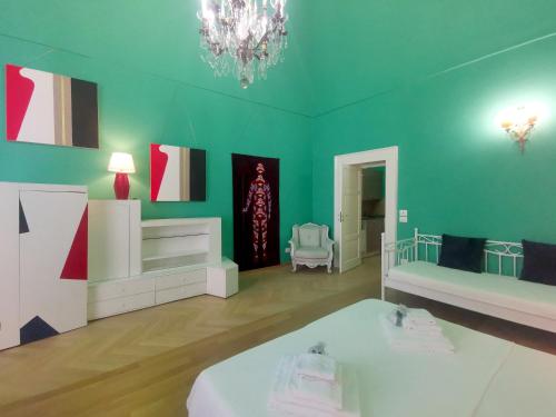 a green room with a bed and a chandelier at Speciale Tarshito Guesthouse Bari in Bari