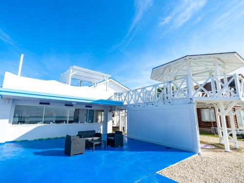 a house on the water with a blue floor at サンセットリゾート　かぬたん in Gushiken