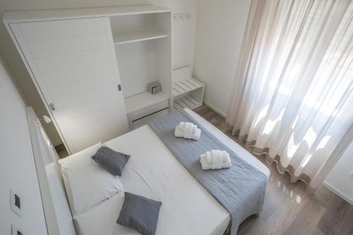 a white room with a table with two pillows on it at Rimini Bay Suites&Residence in Rimini