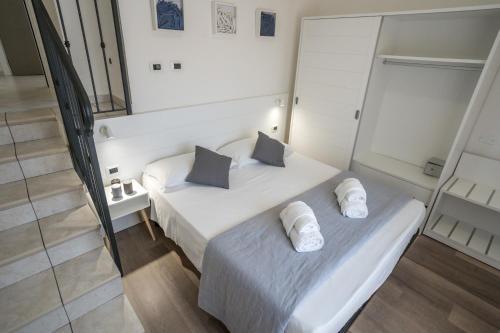 a small bedroom with a white bed with two pillows at Rimini Bay Suites&Residence in Rimini