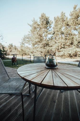 a wooden table and chairs on a wooden deck at House 100 m to the sea in Monciske, free parking in Monciškės
