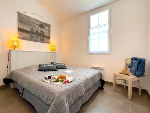 a bedroom with a bed with a tray of food on it at Le Clos des Vieux Moulins in La Flotte