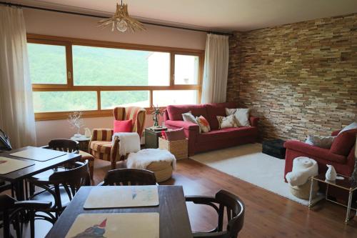 a living room with red furniture and a brick wall at Naquela Castroviejo in Castroviejo