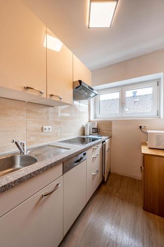 a kitchen with white cabinets and a sink at Beim Franz in Lermoos