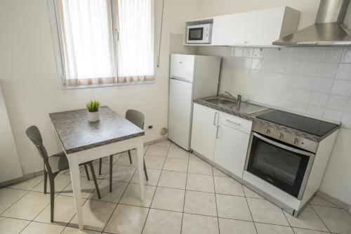 a small kitchen with a table and a refrigerator at Rimini Bay Suites&Residence in Rimini