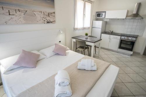 a white bed in a room with a kitchen at Rimini Bay Suites&Residence in Rimini